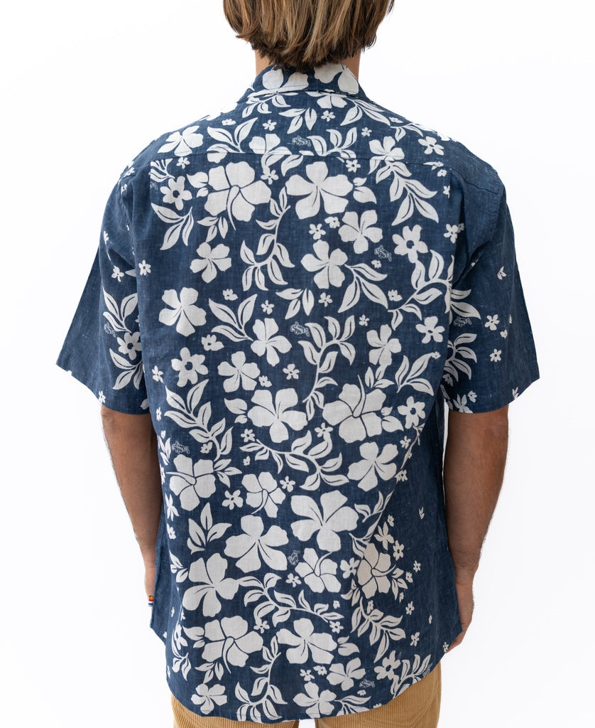 A person wearing the Golden Breed Vomo Floral Shirt in Vintage Navy, featuring a white floral pattern, is photographed from the back against a white background.