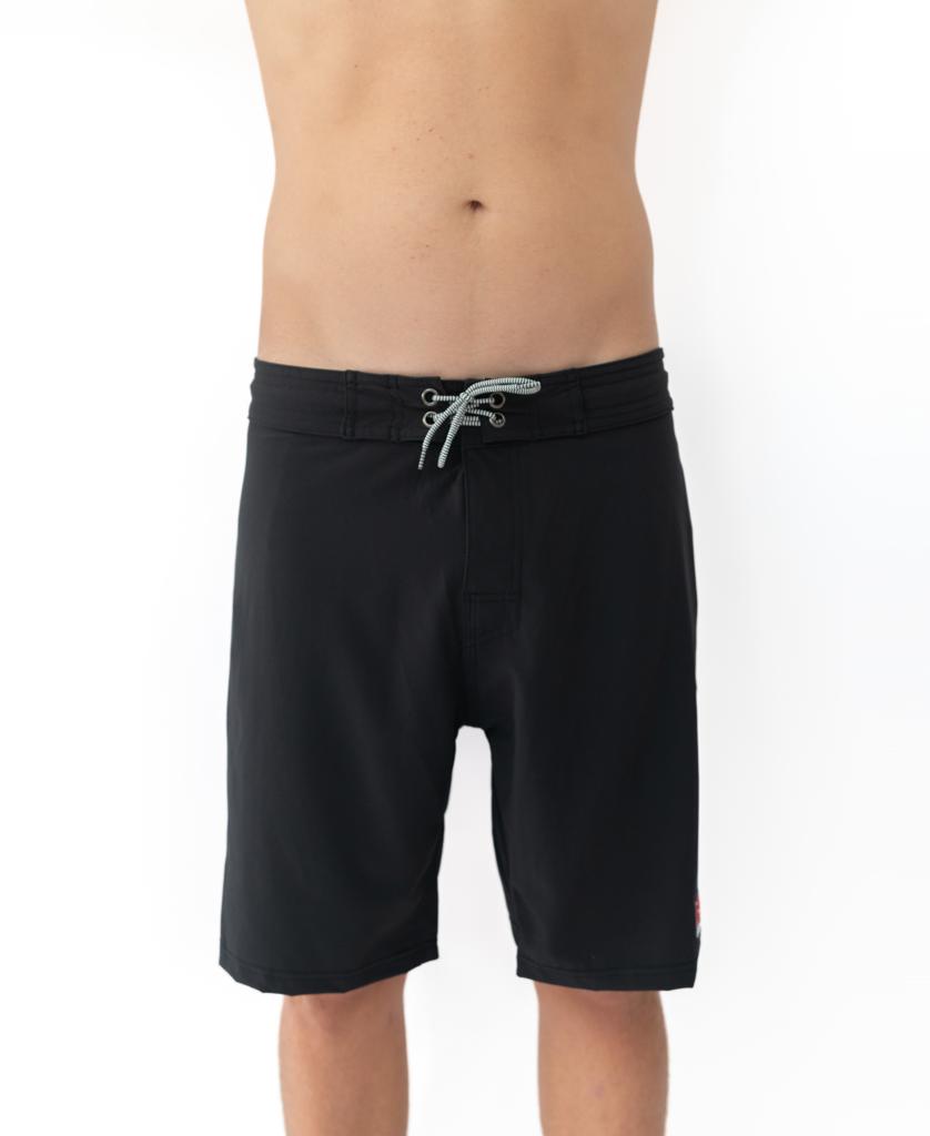 A person wears Gordon & Smith G&S Boardie shorts in black, made from recycled polyester, shown from mid-torso to knees against a plain white background.