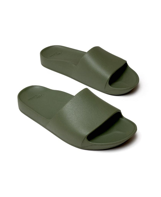 The Archies Archie Slide in Khaki features thick straps, textured soles, and arch support. Made from closed-cell foam that molds to your foot, these olive green slides are shown on a white background.