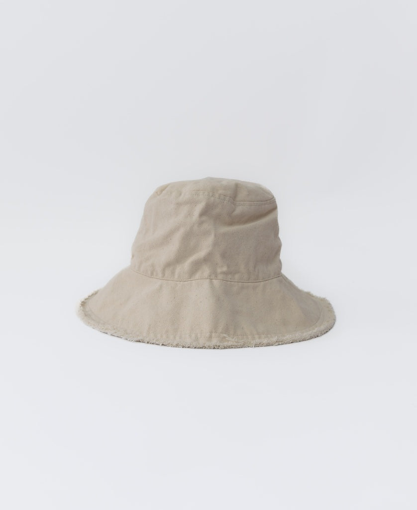 The Halo Bucket Hat | Off White by Lazy Beach is a handmade cotton hat with a wide brim and frayed edges, shown against a plain white background.
