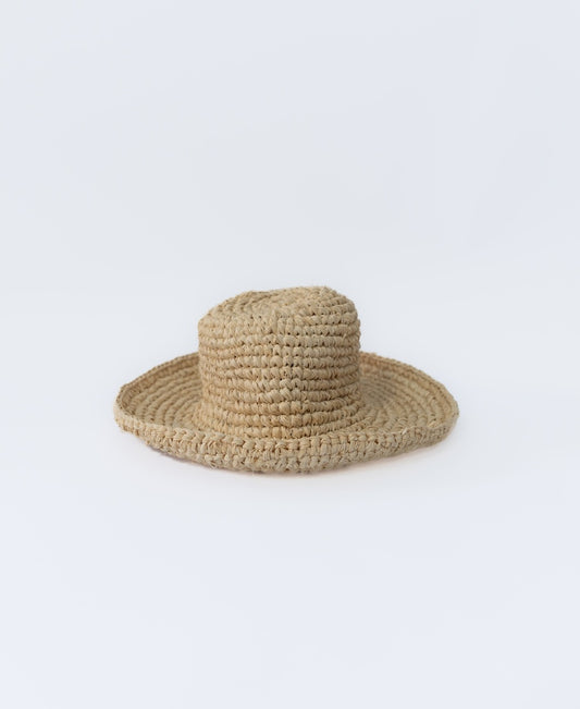 The Lazy Beach Raffia Hat with Brim in off white features a simple woven design and rests on a plain white background—an ideal accessory for summer days.