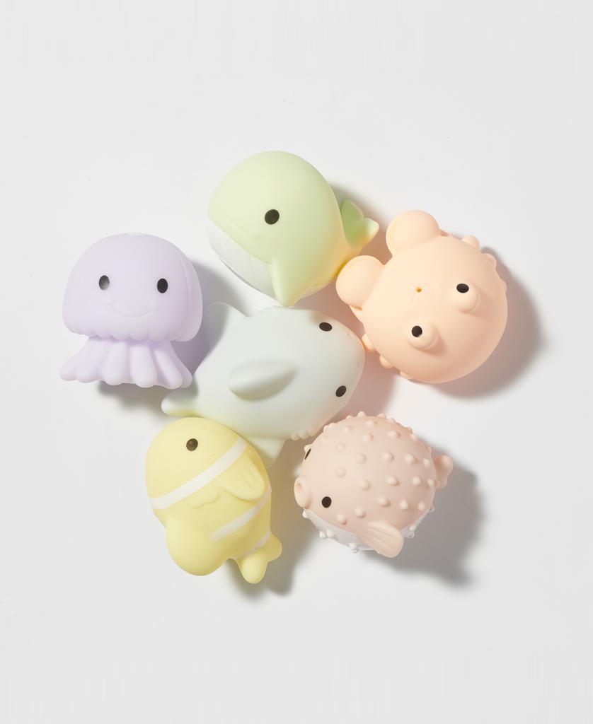 Six pastel Sea Animal Splash Toys Ocean Friends by Sunny Life—including a jellyfish, whale, dolphin, seal, pufferfish, and fish—are arranged in a loose circle on white, ready to delight your little one.