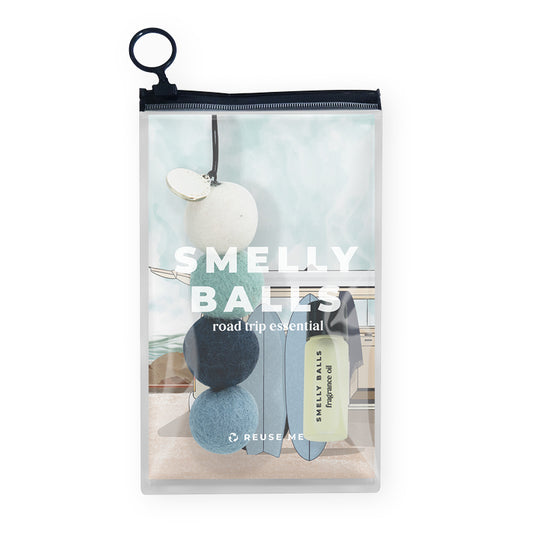 The Smelly Balls Cove Set Coastal Drift includes wool balls and fragrance oil in a clear pouch, featuring a coastal background image and labeled as the beach-inspired road trip essential.