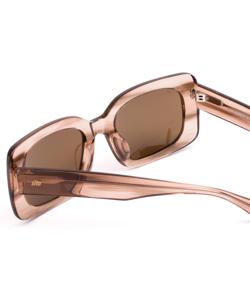 The Sito Indi sunglasses in Biscotti / Brown feature a retro-inspired rectangular frame with translucent brown acetate and matching brown-tinted lenses, shown from a rear side angle.