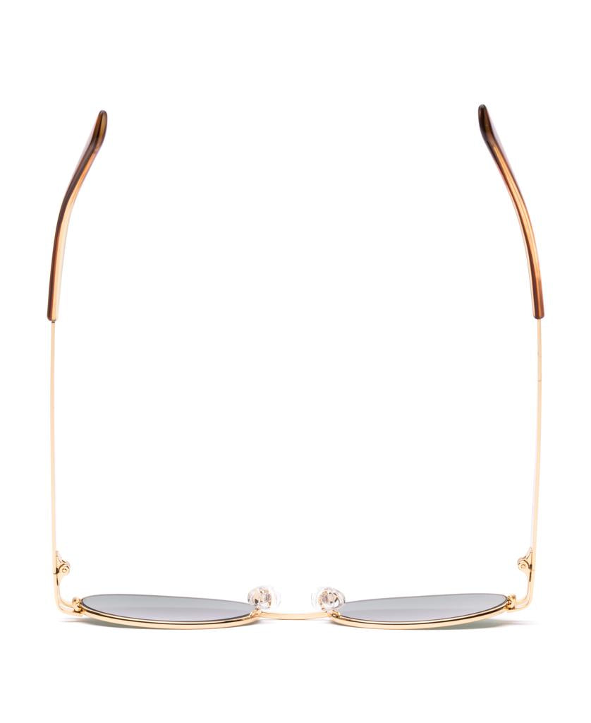 Sitos Stevie sunglasses feature oval gold frames, Tangelo brown-tipped arms, and Slate Polar polarized lenses, shown from the front with lenses facing down.