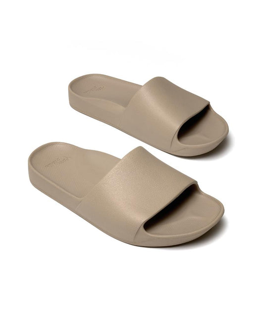 The Archies Archie Slide in taupe features thick single straps and contoured footbeds that mold to your feet, shown against a white background.
